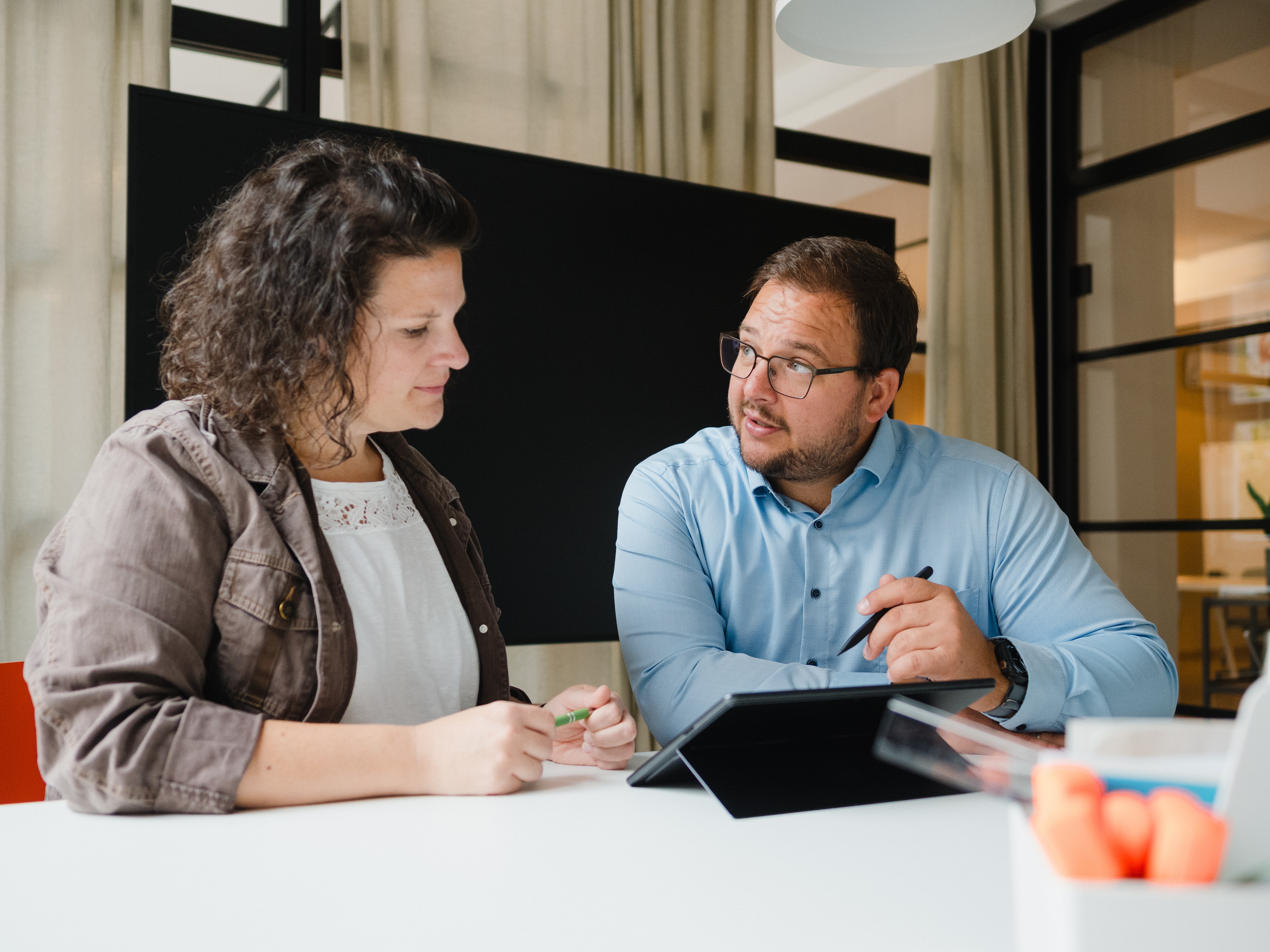 Moderne Business-Fotografie Rhein-Neckar für KMU. Echtes Team-Meeting-Foto in Karlsruhe/Mannheim von Mitarbeitern im Dialog. Ideal für zeitgemäße Unternehmenskommunikation und Website-Inhalte